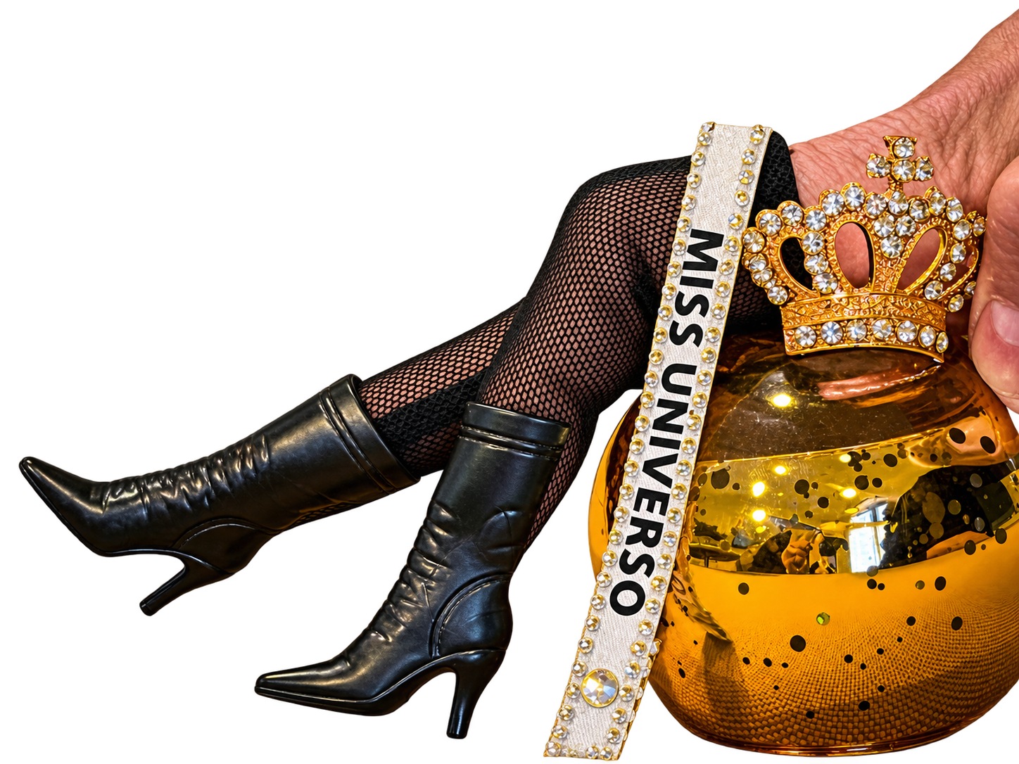Figura con botas negras, banda Miss Universo y corona dorada sobre un escenario rosa